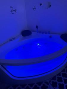 bañera azul en una habitación con luz azul en استديو بجاكوزي وكراج دخول ذاتي, en Ar Ruqayyiqah