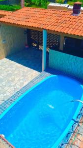 马拉戈日Casa Praia Maragogi - Peroba的蓝色游泳池,带有橙色屋顶