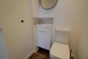 bagno con servizi igienici bianchi e specchio di Lovely Bakewell apartment a Bakewell