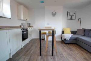 a kitchen and living room with a table and a couch at Lovely Bakewell apartment in Bakewell