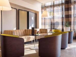 a lobby with a couch and a table and chairs at Mercure Lyon Centre Brotteaux in Lyon