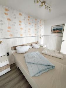 una camera con due letti e un muro con fiori di Ferienpark E11-007 Ferienpark a Heiligenhafen