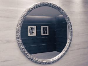 a mirror hanging on a wall with three framed pictures at Mercure Hotel Sapporo in Sapporo