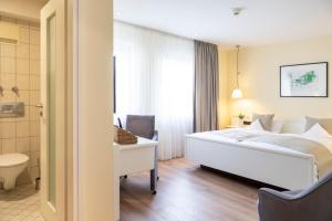 a hotel room with a bed and a desk at Hotel Deutscher Hof in Trier +33 photos