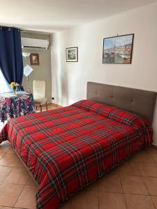 una camera con un letto con una coperta rossa a scacchi di Maison Romantique a Napoli