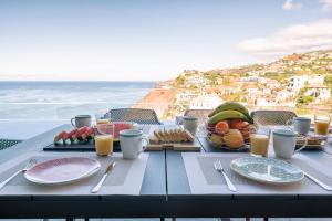 - une table avec de la nourriture et une vue sur l'océan dans l'établissement Villa Ocean Haven by AH, à Ribeira Brava