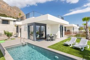 a villa with a swimming pool and a house at Casa con piscina climatizada y vistas al mar in Polop