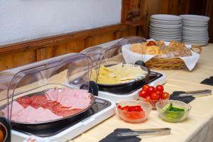 a table topped with trays of different types of food at Hotel Heimgartl in Innsbruck