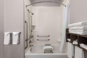 a white bathroom with a tub and towels at La Quinta by Wyndham Rapid City in Rapid City