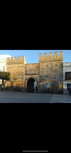 a large brick building with a gate in front of it at TURISMO LOS LANCES TARIFA( PARKING GRATUITO) in Tarifa