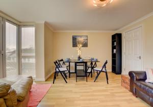 uma sala de estar com uma mesa de jantar e cadeiras em Bowleaze Beach Apartment em Weymouth