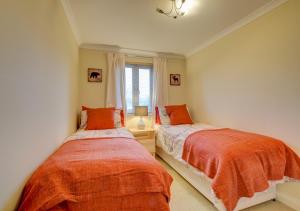 2 Einzelbetten in einem Zimmer mit Fenster in der Unterkunft Bowleaze Beach Apartment in Weymouth