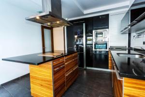 a kitchen with black counter tops and wooden cabinets at KARRAKELLA apartamentua con aire in Orio