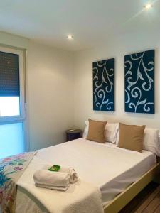 a bedroom with a large bed with two paintings on the wall at KARRAKELLA apartamentua con aire in Orio