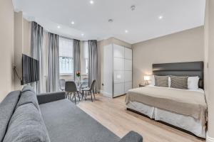 a hotel room with a bed and a couch at Cleveland Residences Chelsea in London
