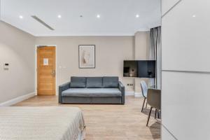 ein Wohnzimmer mit Sofa und Fernseher in der Unterkunft Cleveland Residences Chelsea in London