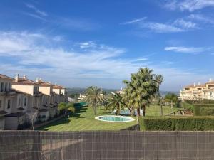 a view of a yard with palm trees and a pool at Casa con jardín, wifi, aire acondicionado, piscina in Ayamonte