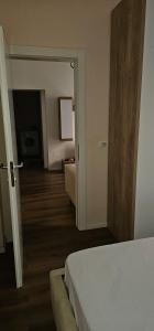 een hotelkamer met een bed en een hal bij Ajla Komuna Apartament in Tirana