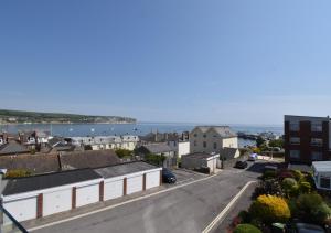 a city street with buildings and the ocean in the background at Tuppence View in Swanage