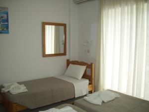 a bedroom with two beds and a mirror and a window at Your Second Home 2 in Kámpos