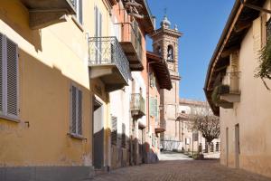 un callejón en un casco antiguo con una torre de reloj en Casa Vacanze La Porta in Piazza, en Guarene