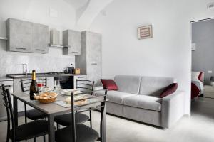een woonkamer met een tafel en een bank bij Casa Vacanze La Porta in Piazza in Guarene