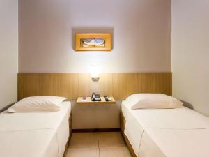 Cama ou camas em um quarto em ibis Styles Belém do Pará