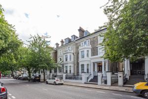 a white car parked in front of a large building at Cleveland Residences Chelsea in London
