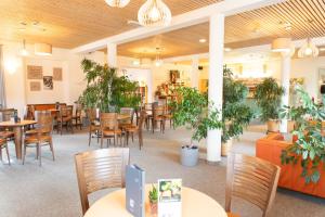 a restaurant with tables and chairs and potted plants at JUFA Hotel Pöllau in Pöllau +21 photos