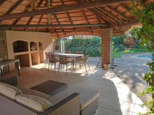 a patio with a table and chairs under a wooden pergola at Harmony Place in Klerksdorp
