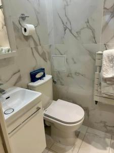 فندق ديربي إيفل في باريس: حمام ابيض مع مرحاض ومغسلة