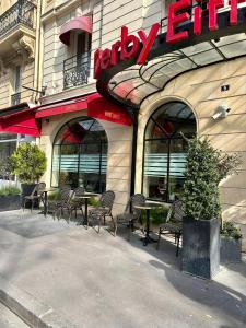 um restaurante com cadeiras e mesas em frente a um edifício em Hôtel Derby Eiffel em Paris