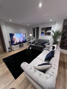 een woonkamer met 2 banken en een flatscreen-tv bij Drillz Stays in Manchester