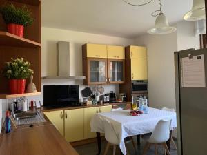 cocina con mesa y cocina con armarios amarillos en Casa Carlotta - Milan Expo, en Arese