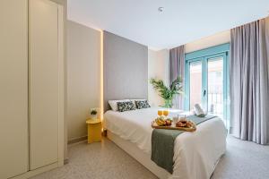 sypialnia z łóżkiem i tacą z owocami w obiekcie SUNSET MALAGA - PRIME & DESIGN w Maladze