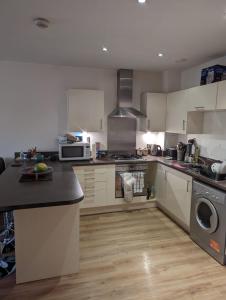 a kitchen with white cabinets and a counter top at Charming bedroom in a shared 2-Bedroom Flat in Southall, London (next to Ealing Hospital). in London