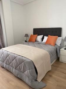 a bedroom with a large bed with orange pillows at Apartamento Plaza de las Flores in Murcia