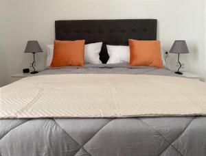 a bedroom with a large bed with orange pillows at Apartamento Plaza de las Flores in Murcia