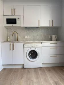 a white kitchen with a washing machine in it at Apartamento Plaza de las Flores in Murcia