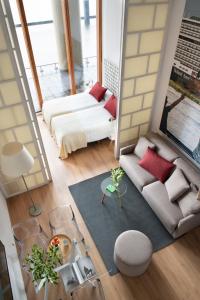 Eric Vökel Boutique Apartments - Riverfront Suites في أمستردام: غرفة معيشة مع أريكة وسرير