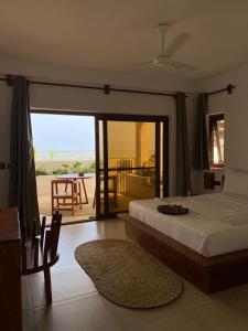 a bedroom with a bed and a view of the beach at Aluna Beach Apartments in Nungwi