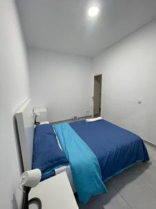 a bedroom with a blue bed and a chair at Buen sitio para hospedarse in Barcelona