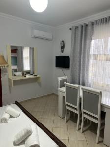een kamer met een bureau en een tafel en stoelen bij Villa Kevin's in Sarandë