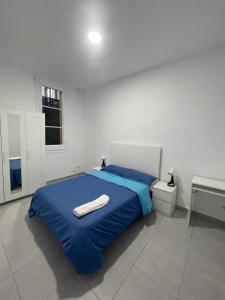 a bedroom with a blue bed and a window at Buen sitio para hospedarse in Barcelona