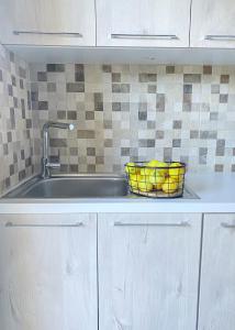 a kitchen sink with a basket of bananas in it at Nikol's House in Chania Town