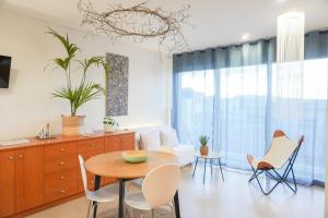 cocina y sala de estar con mesa y sillas en Costa Brava acollidor apartament amb gran terrassa per a 3 persones, en Castelló d'Empúries