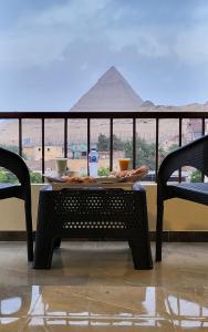 uma mesa com comida e vista para as pirâmides em AliBaba Pyramids View Inn no Cairo