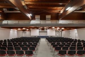 una sala de conferencias vacía con sillas negras y pizarras en UNAHOTELS Bologna San Lazzaro, en San Lazzaro di Savena