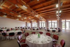 um salão de banquetes com mesas e cadeiras brancas em UNAHOTELS Bologna San Lazzaro em San Lazzaro di Savena