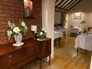 una habitación con un jarrón de flores en una cómoda en Cotswold House, en Oxford